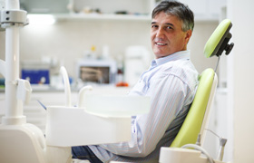 Patient smiling while sitting in treatment chair